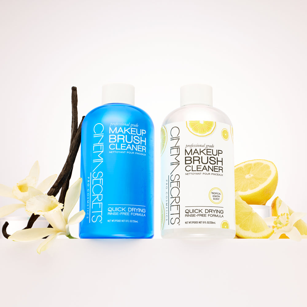Blue brush cleaner to the left with vanilla beans and flowers. Tropical Lemon brush cleaner bottle to the right with fresh cut lemons 