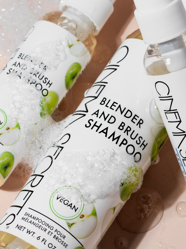 Bottles of Blender and Brush Shampoo with visible branding on a textured surface.