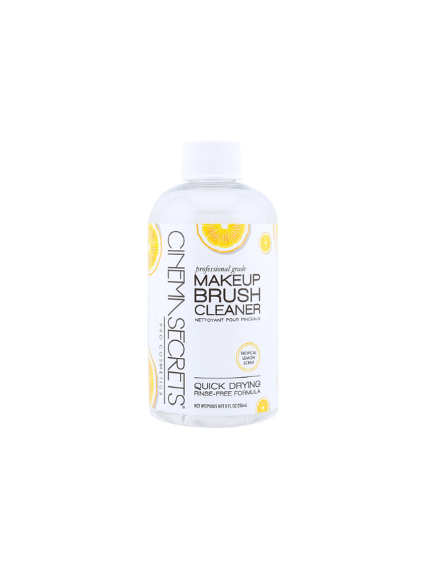 Makeup brush cleaner bottle with lemon slices on a white background