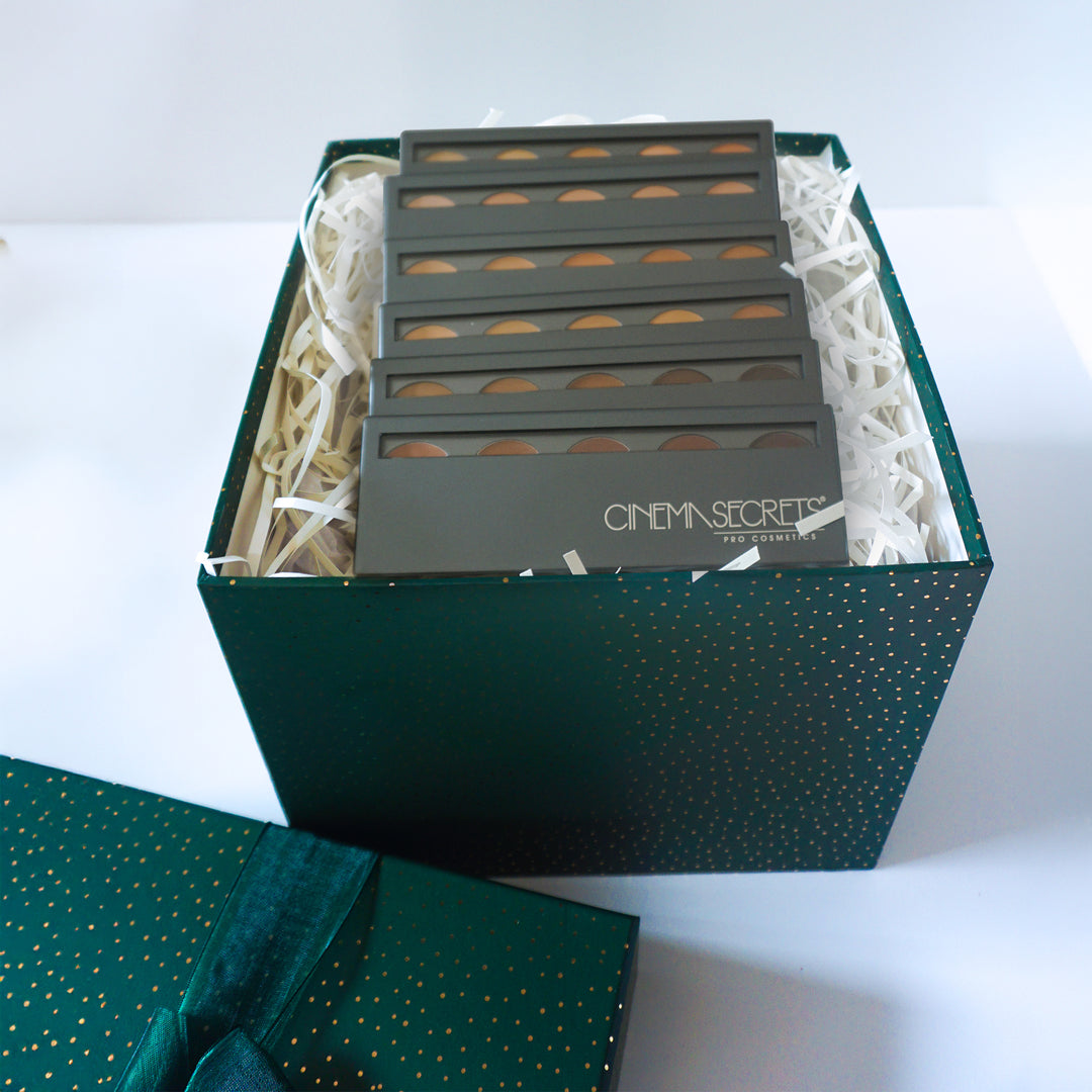 Set of Cinema Secrets makeup products in a green box on a white background