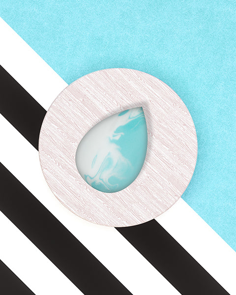 teardrop blue and white sponge on white wood, bluel and black and ehite striped background