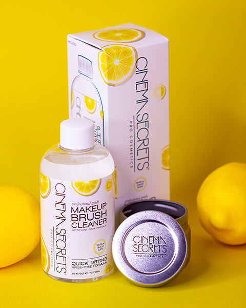 bottle of brush cleaner, box, and tin with lemon on a yellow background